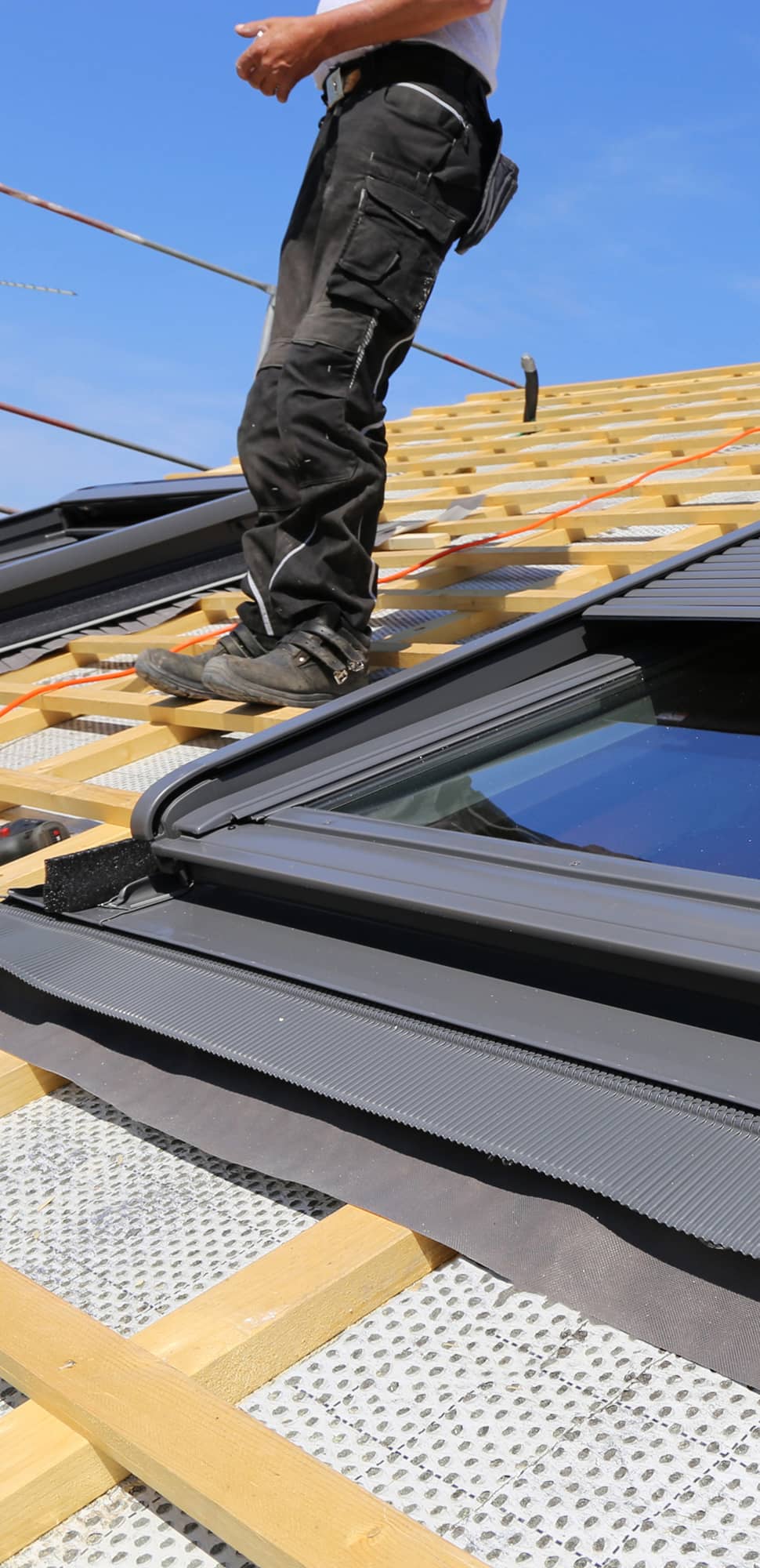 Dachdecker installiert Dachfenster – Einbau mit Abdichtungsrahmen auf einem Neubaudach