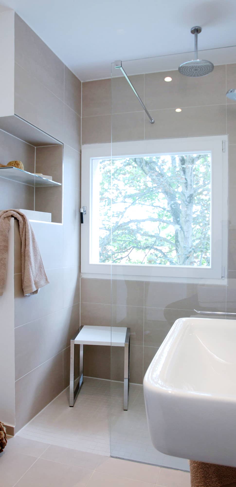 Bad sanieren – modernes Badezimmer mit bodenebener Dusche, Deckenregendusche und großformatigen Beigefliesen