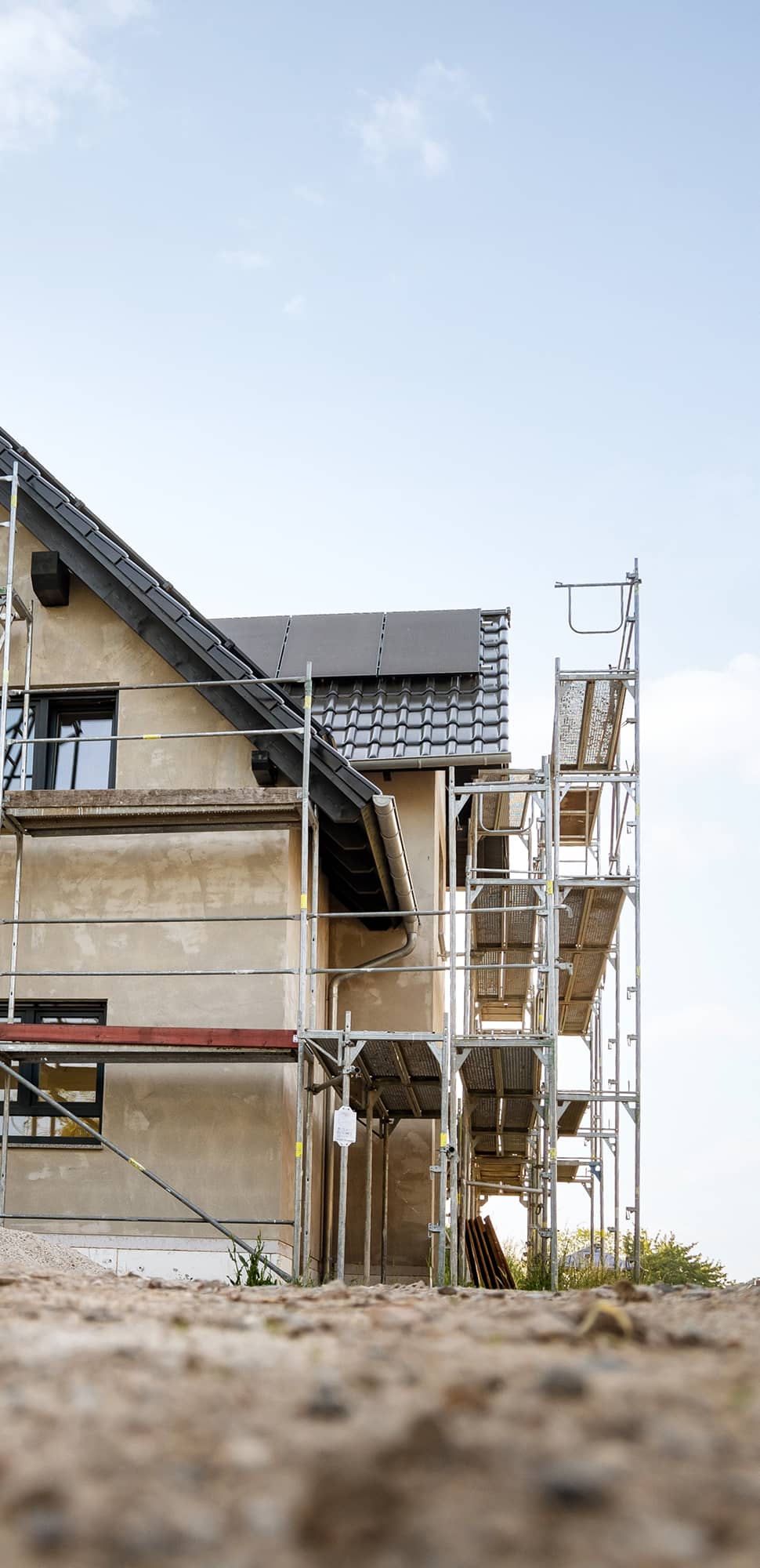 Gutachten – Rohbau eines Wohnhauses mit Gerüst und neu eingedecktem Dach bei laufenden Bauarbeiten
